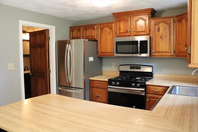 139 Wellman Ave Unit 139, Chelmsford, MA 01863 - kitchen with stainless steel appliances, light countertops, and brown cabinets
