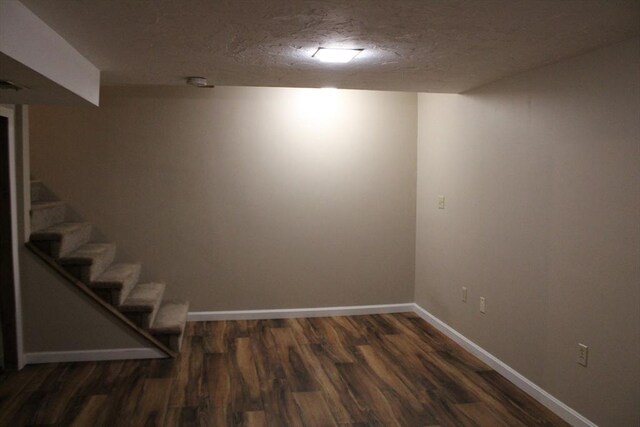 139 Wellman Ave Unit 139, Chelmsford, MA 01863 - finished basement with dark wood-style flooring, stairway, and a textured ceiling