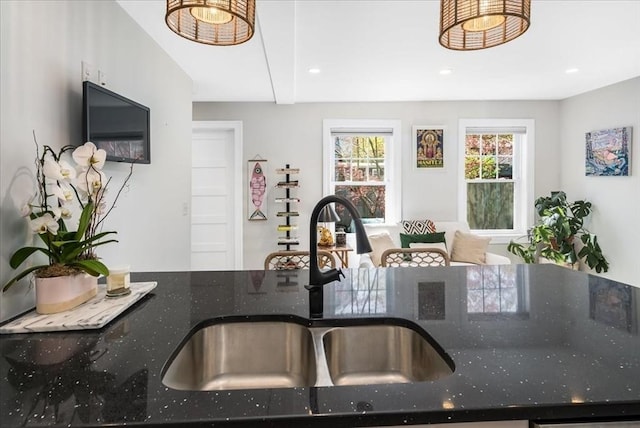 kitchen featuring recessed lighting, a sink, and dark stone countertops