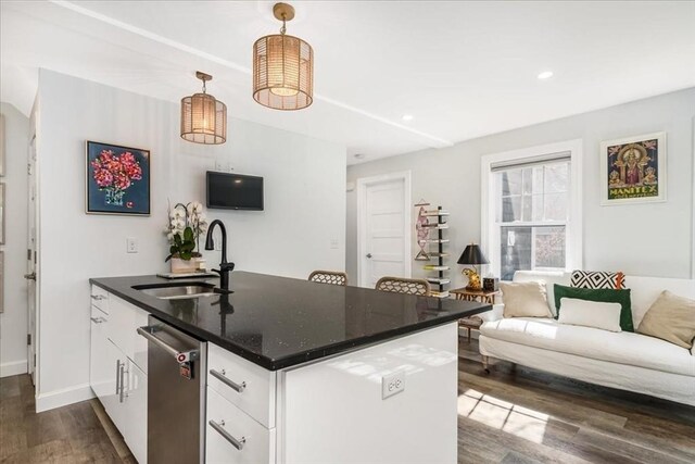 kitchen featuring stainless steel dishwasher, a sink, dark wood finished floors, and white cabinets