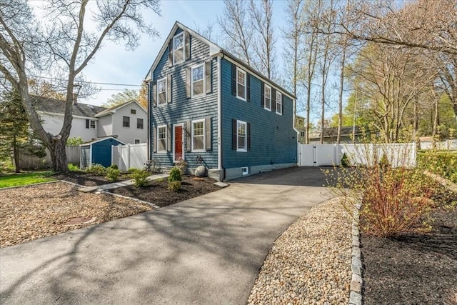 view of front of house with a gate, aphalt driveway, and fence