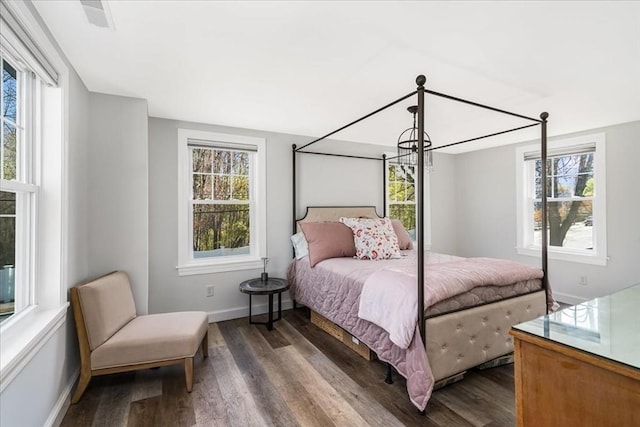 bedroom featuring baseboards, dark wood-style floors, and multiple windows