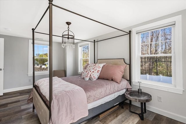 bedroom with baseboards, multiple windows, and a chandelier