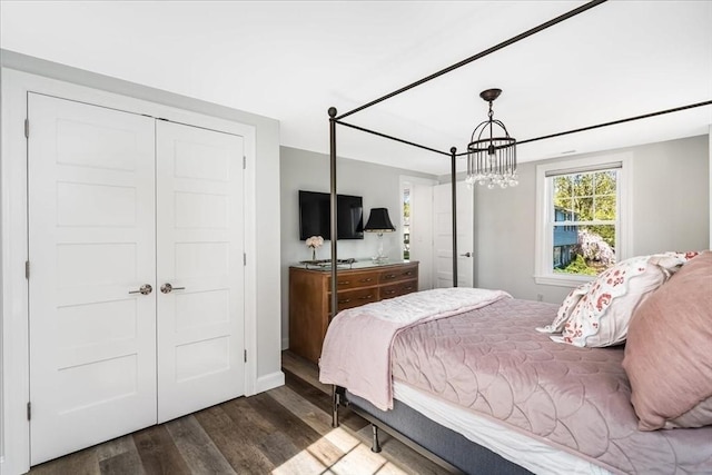 bedroom featuring a closet, wood finished floors, and a chandelier