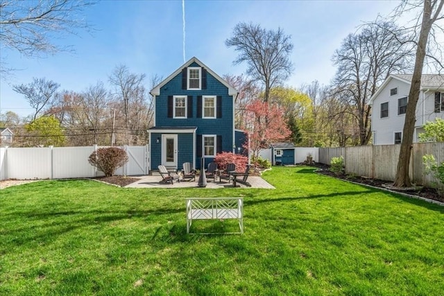 rear view of house featuring a fenced backyard, a yard, a patio area, and a storage shed