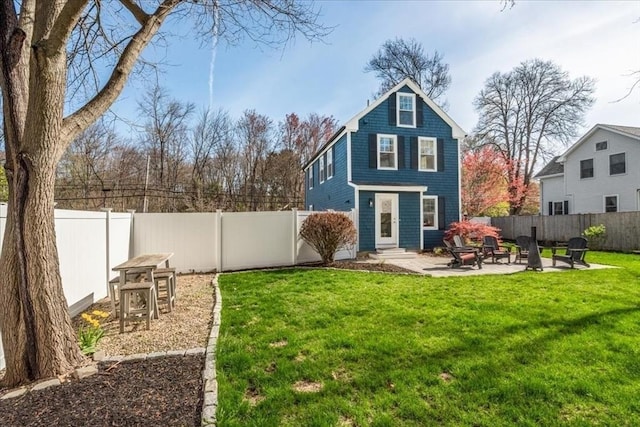 rear view of property featuring a yard, a patio, a fenced backyard, and entry steps