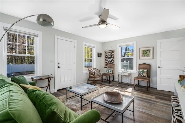 living room with ceiling fan, plenty of natural light, baseboards, and wood finished floors