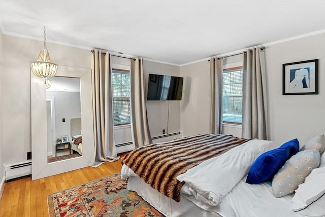 bedroom featuring ornamental molding, multiple windows, and light wood finished floors