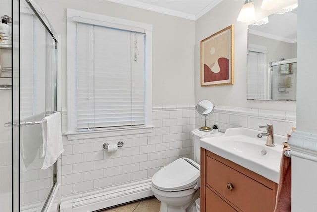 bathroom featuring toilet, tile walls, vanity, a shower with door, and crown molding