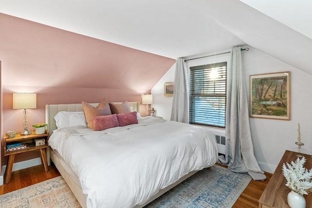 bedroom featuring vaulted ceiling, wood finished floors, and baseboards