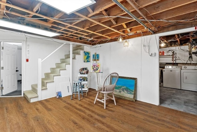 unfinished below grade area featuring stairs, wood finished floors, and washing machine and clothes dryer