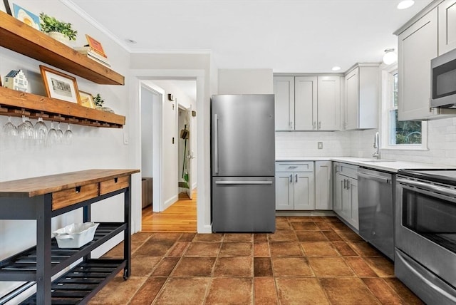 kitchen featuring stainless steel appliances, gray cabinets, light countertops, and a sink