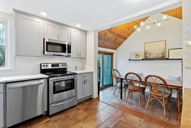 kitchen with backsplash, gray cabinets, stainless steel appliances, and light countertops