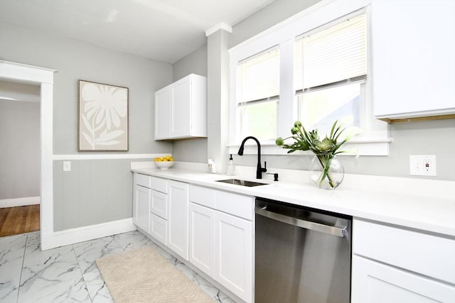 kitchen featuring a sink, a wainscoted wall, marble finish floor, white cabinetry, and dishwasher