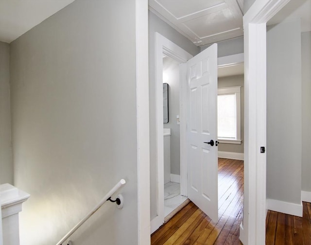 corridor featuring an upstairs landing, hardwood / wood-style floors, and baseboards