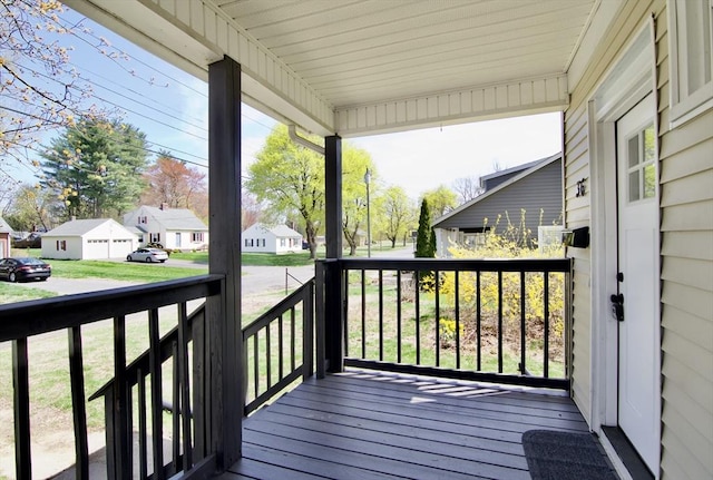 deck with a residential view, a yard, and covered porch