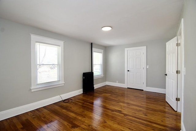 unfurnished room featuring hardwood / wood-style floors and baseboards