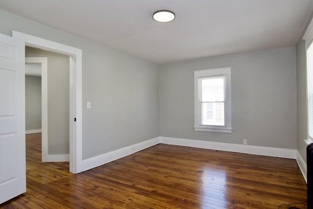 empty room featuring dark wood-style floors and baseboards