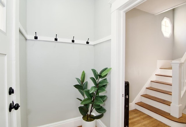 staircase featuring wood finished floors and baseboards