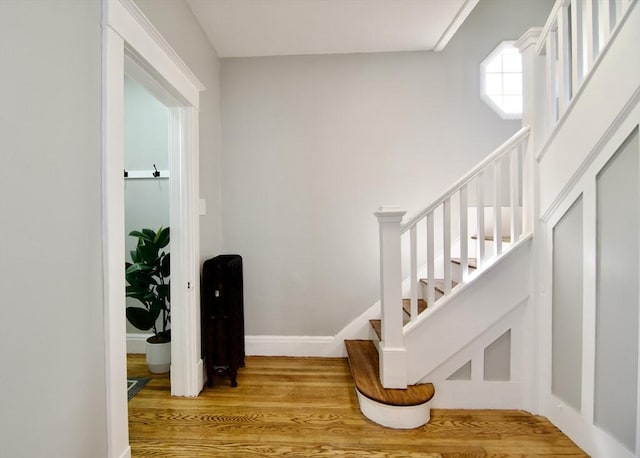 staircase with baseboards and wood finished floors