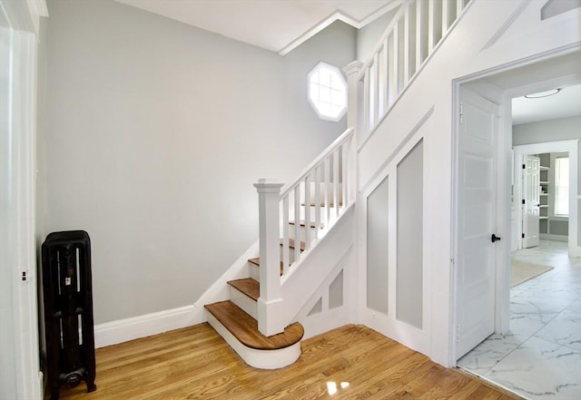 stairs featuring marble finish floor and baseboards