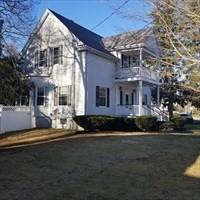 view of side of property featuring a balcony and a yard