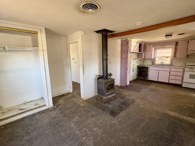 kitchen with sink, decorative backsplash, beverage cooler, white gas stove, and a wood stove