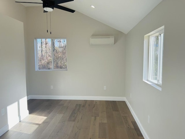 empty room featuring a wall unit AC, ceiling fan, hardwood / wood-style floors, and vaulted ceiling