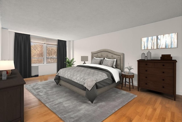 bedroom with light wood-style floors and a textured ceiling