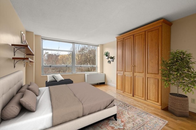 bedroom with light wood-style flooring and radiator