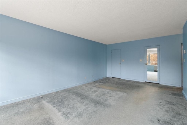 interior space with baseboards, carpet floors, and a textured ceiling