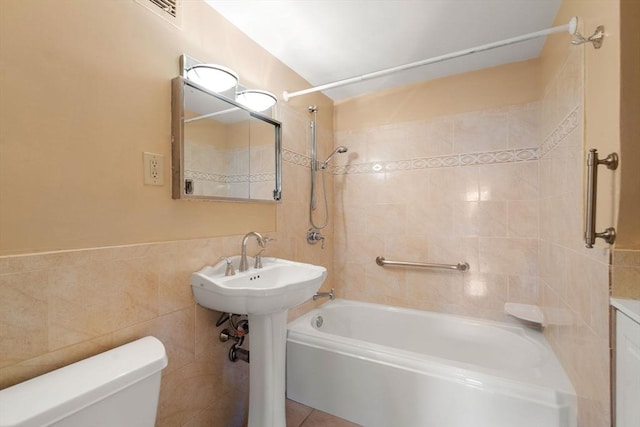 full bath featuring tub / shower combination, toilet, tile walls, and tile patterned flooring