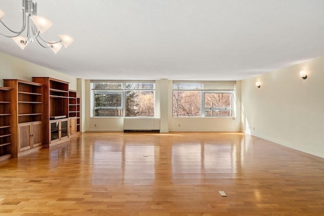 unfurnished living room with baseboards and light wood-style floors