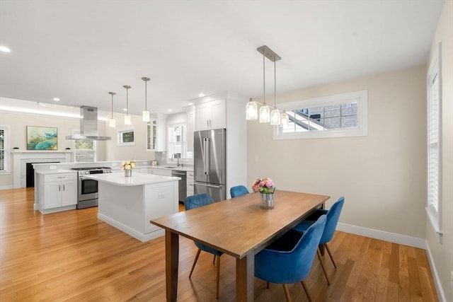 dining room with recessed lighting, baseboards, and light wood finished floors