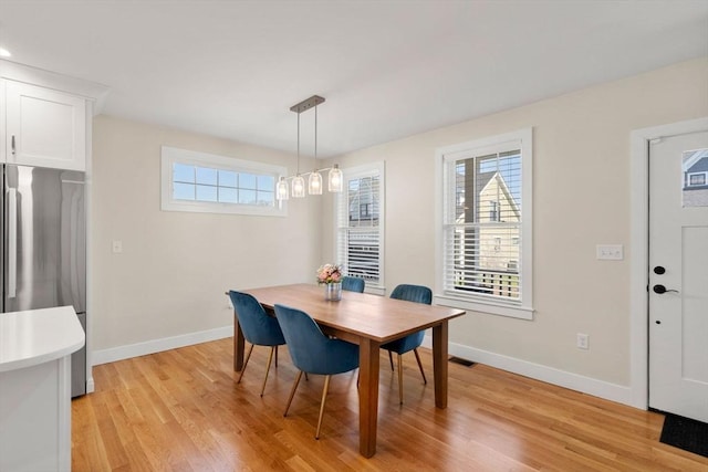 dining space featuring light wood-style floors and baseboards