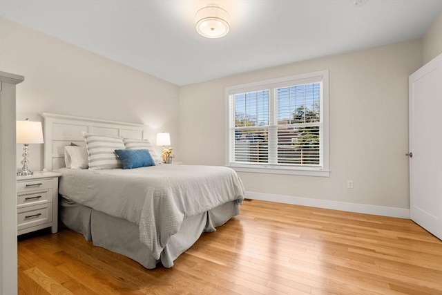 bedroom featuring baseboards and light wood-style flooring