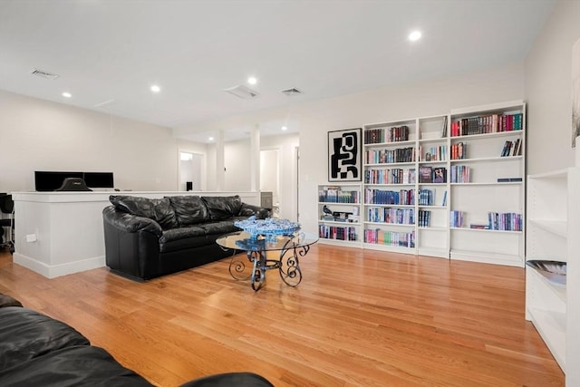 living area with attic access, recessed lighting, wood finished floors, and visible vents