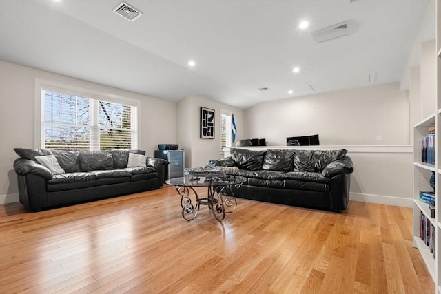 living room with baseboards, plenty of natural light, wood finished floors, and visible vents