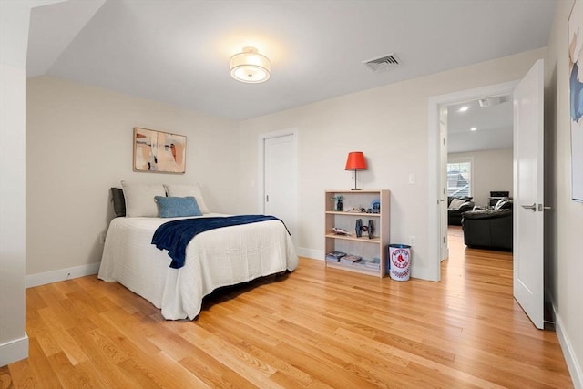 bedroom featuring baseboards, visible vents, and light wood-style floors