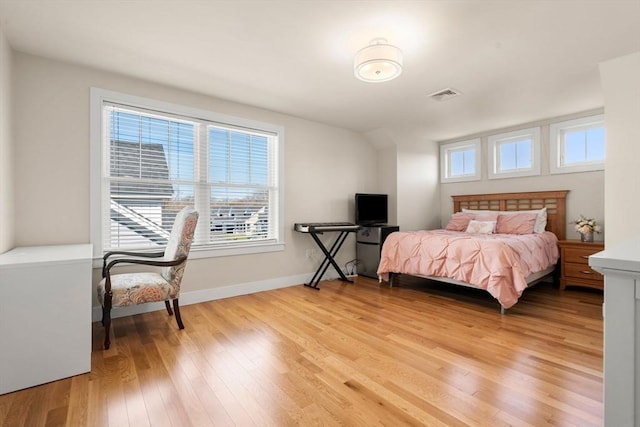 bedroom with baseboards, light wood-style flooring, and visible vents