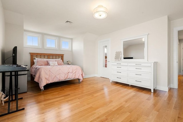 bedroom with baseboards, visible vents, and light wood finished floors