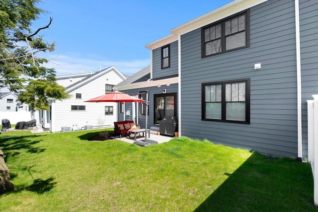 rear view of house featuring a lawn and a patio