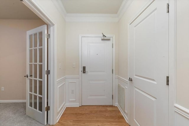 1 Francis Dr Unit 211, Andover, MA 01810 - doorway featuring crown molding, a decorative wall, wainscoting, and light wood-style floors