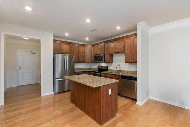 1 Francis Dr Unit 211, Andover, MA 01810 - kitchen with appliances with stainless steel finishes, a sink, a center island, light stone countertops, and light wood finished floors