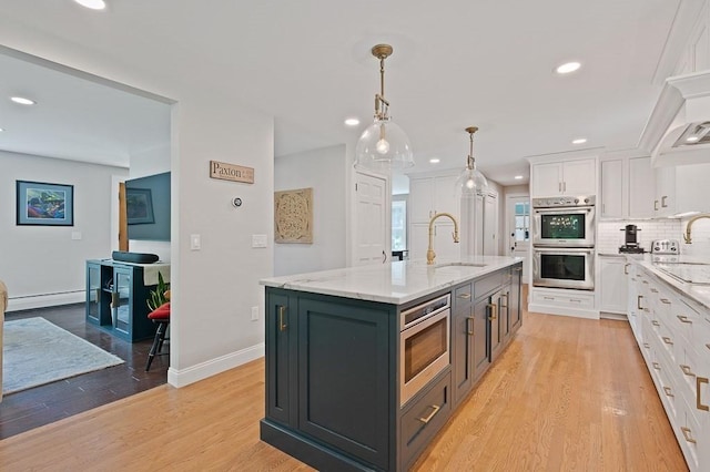 3 Squantum Rd, Paxton, MA 01612 - kitchen featuring appliances with stainless steel finishes, a sink, white cabinets, light wood-type flooring, and tasteful backsplash