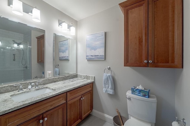 bathroom with a tile shower, toilet, tile patterned flooring, and vanity