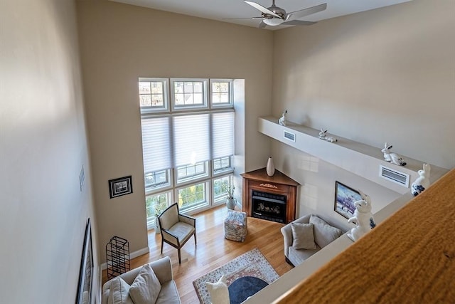 living room featuring ceiling fan, light hardwood / wood-style flooring, and a healthy amount of sunlight