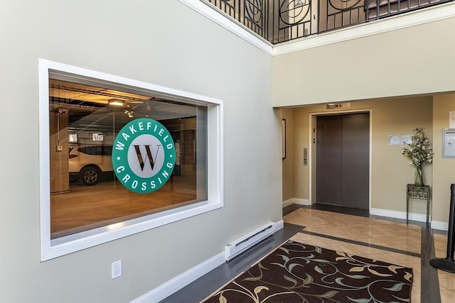 tiled entrance foyer featuring a baseboard heating unit and elevator