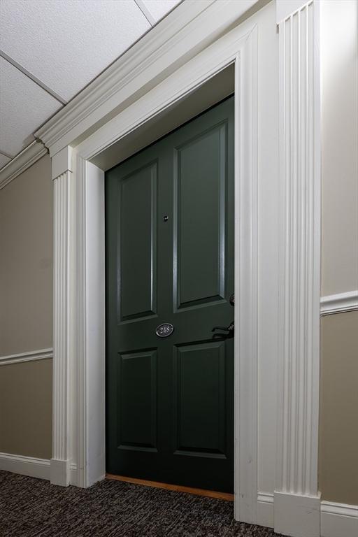 interior space featuring crown molding and dark colored carpet