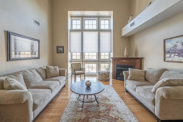 living room with light wood-type flooring and a high ceiling